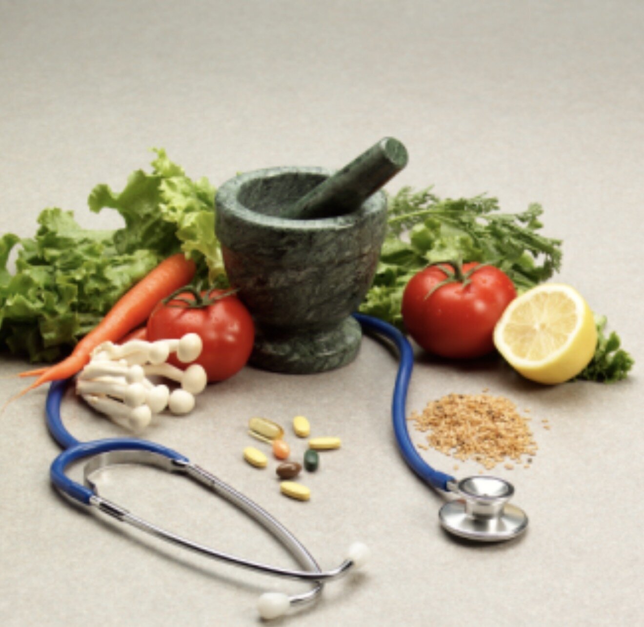 Fresh vegetables, herbs, and a mortar and pestle on a work surface